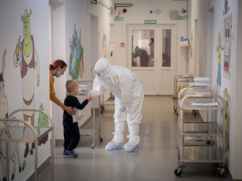 Un gest de dragoste! O asistentă ține în brațe un copil cu COVID