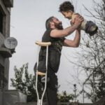 O fotografie cu un tată ridicându-și fiul născut fără mâini și picioare a emoționat întreaga lume
