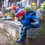 Un băiat vizitează mormântul mamei cu un buchet din florile ei preferate, un străin apare lângă el cu aceleași flori