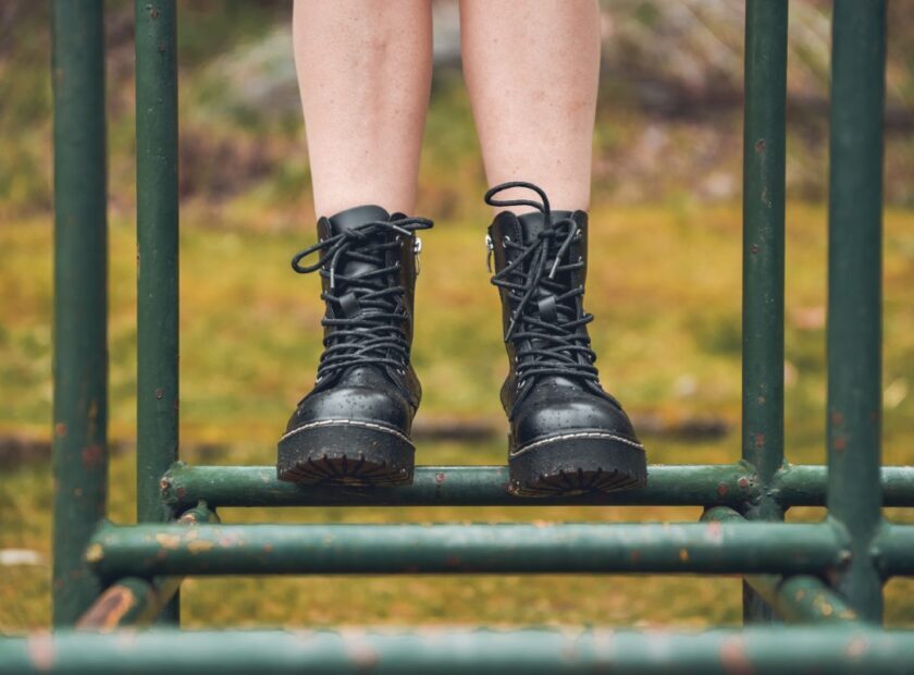 Person with boots on park swing