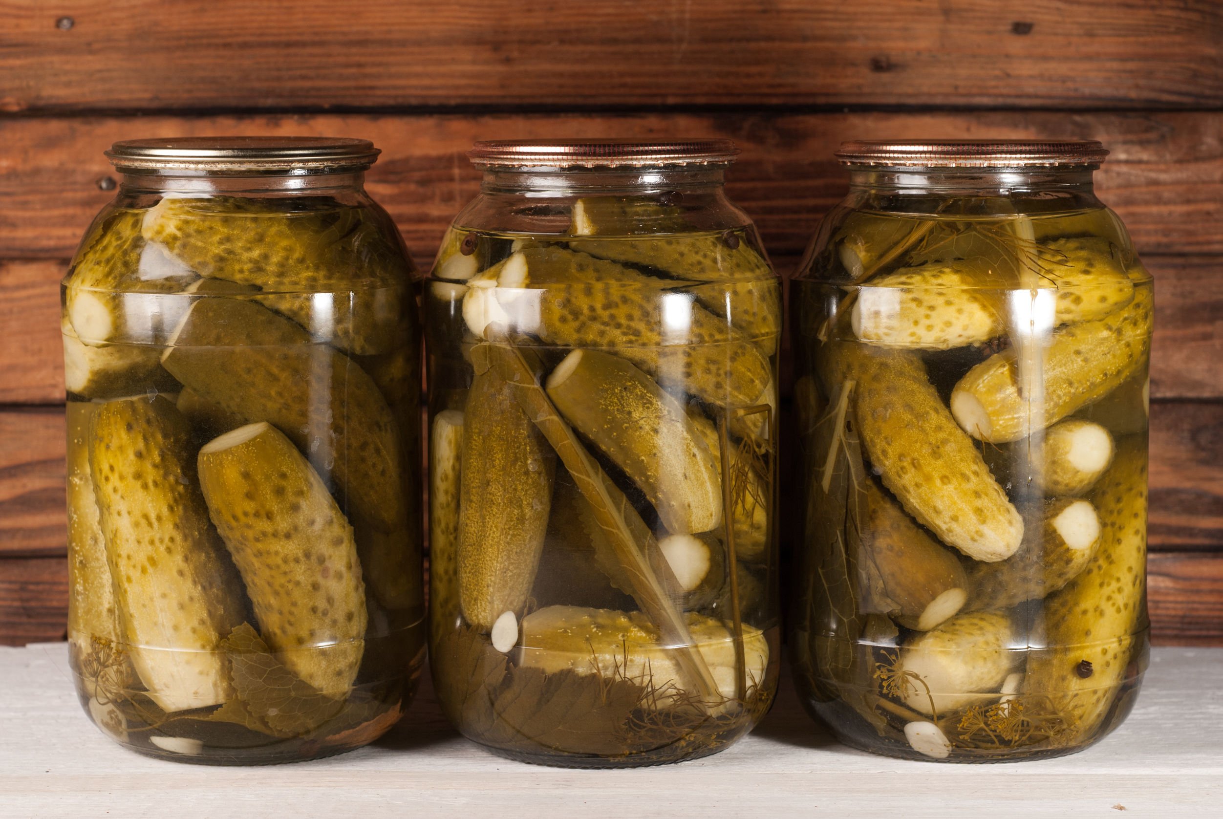 83890675 - pickled cucumbers on wooden background. pickled cucumbers in a jar