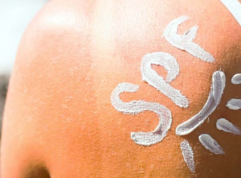 spf written using sunscreen on woman's shoulder
